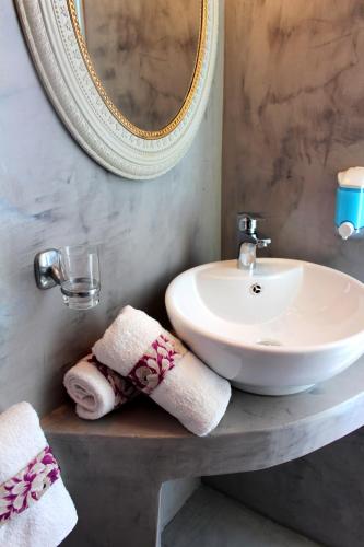 a bathroom with a sink and a mirror and towels at George's Place in Ios Chora