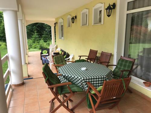 a patio with a table and chairs on a porch at Silvanus Panzió in Lenti