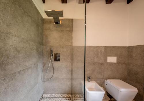 een badkamer met een douche, een toilet en een wastafel bij Chalet Silenthia in Ledro
