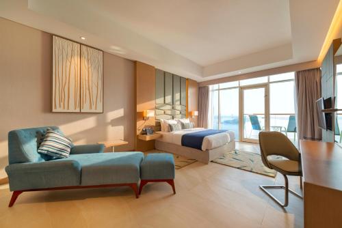 a hotel room with a bed and a couch at Royal Central Hotel and Resort The Palm in Dubai