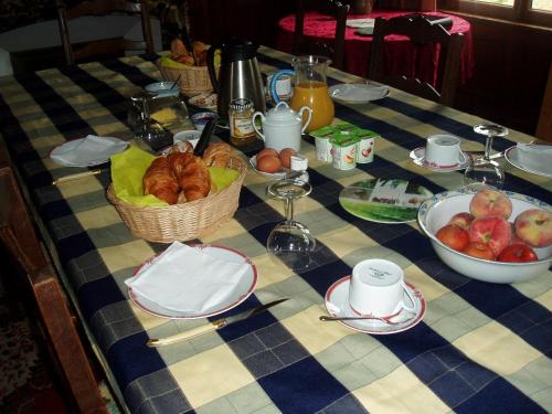 een tafel met manden brood en fruit erop bij Les Poteries in Fresville