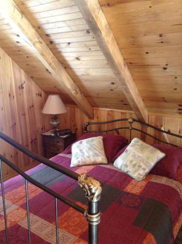 un lit dans une chambre avec un plafond en bois dans l'établissement Chalet d'Anna, à Saint-Damien