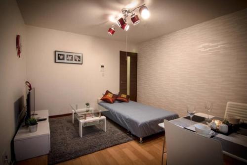 a bedroom with a bed and a living room at Forest Terrace Tenjinminami in Fukuoka