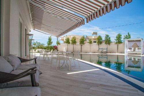 a patio with a table and chairs next to a swimming pool at Hotel Villa Pascucci in Durrës