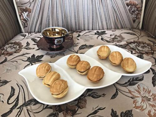 two plates of biscuits and a cup of tea on a couch at House in Quba in Quba