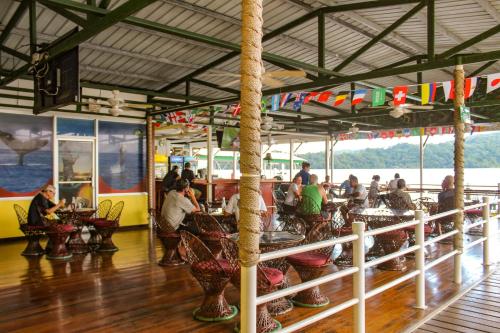 a group of people sitting at tables in a restaurant at Banana Bay Marina in Golfito