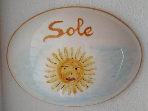 a white plate with a sun with the word sake at Le rondini di San Donato in Lucca