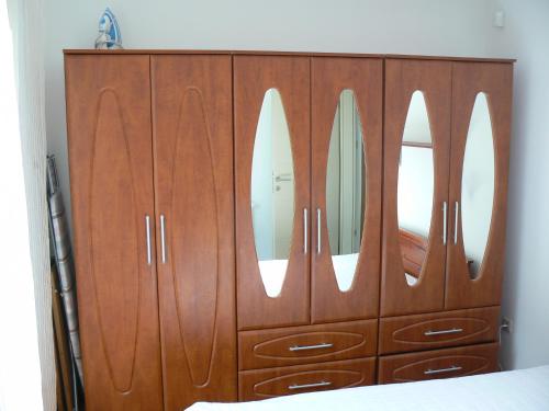 バラトナサードにあるHullám Apartmanのベッドルームに鏡2つ付きの木製ドレッサー