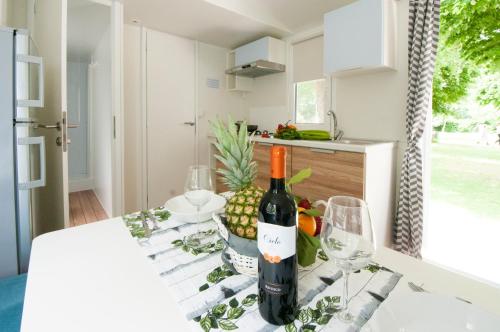 a bottle of wine sitting on a table in a kitchen at Camping Serenissima in Malcontenta