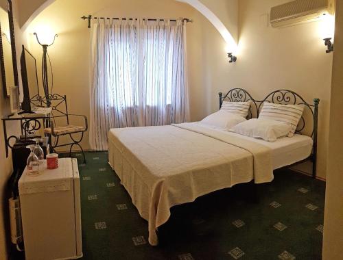 a bedroom with a bed with white sheets and a window at A&B Home Hotel in Göcek