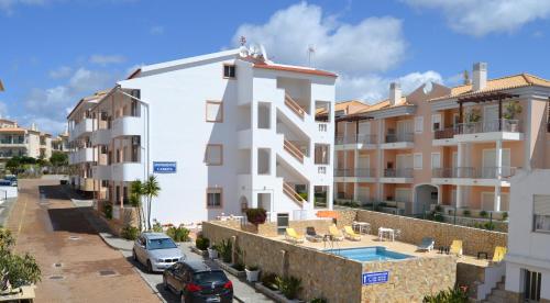 an apartment building with cars parked in front of it at Apartamentos Cabrita in Albufeira