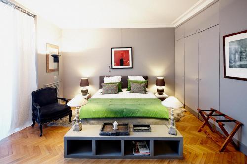 a bedroom with a green bed and a black chair at Maison d'hôtes Bordeaux Centre Le Patio de l'Intendance in Bordeaux