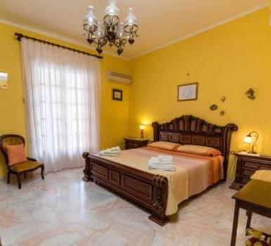 a bedroom with a large bed and a chandelier at Casa Mare e Monti Castelbuono in Castelbuono