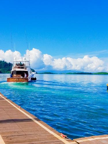 a boat in the water next to a dock at Banana Bay Marina in Golfito