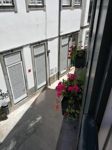 an outside view of a building with flowers and windows at Casa da Travessa in Ponte de Lima