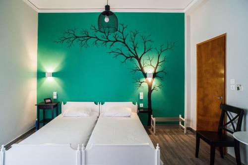 a bedroom with a white bed and a green wall at Aggeliki-Smaro Studios in Neos Pirgos