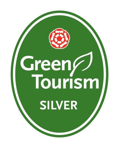 a green sign with a green tourism sliver in it at The Hideaway Huts in Bardon Mill