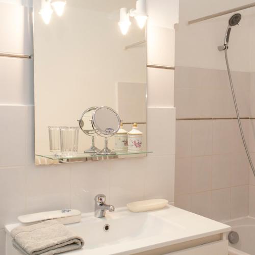 une salle de bain blanche avec un lavabo et un miroir dans l'établissement 46FM : Montauban Guest House, à Montauban