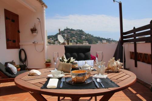 a table on a balcony with a view of a mountain at La Magnòlia i L´Alzina in Blanes