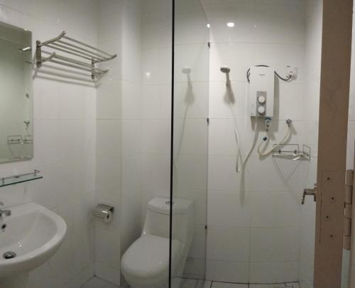 a white bathroom with a toilet and a sink at ExcluSuites Malacca @ The Wave Residence in Melaka