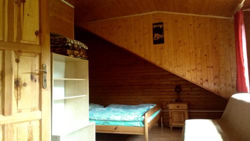 Chata U Jozefa في Malý Lipník: غرفة نوم بسرير في كابينة خشبية