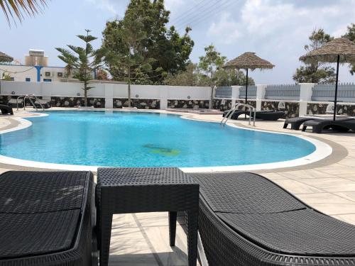 a large swimming pool with blue water in a resort at Black Coast Santorini in Perivolos