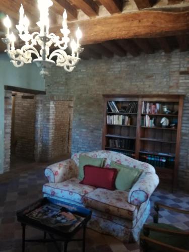 a living room with a couch and a chandelier at Hospitale I Mori in Asola
