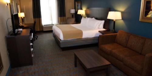 a hotel room with a bed and a couch at Holiday Inn Express Hotel & Suites Goldsboro - Base Area by IHG in Goldsboro