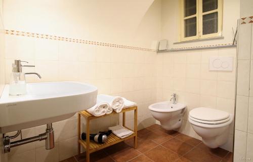 uma casa de banho branca com um lavatório e um WC em B&B U Campanin em Dolceacqua