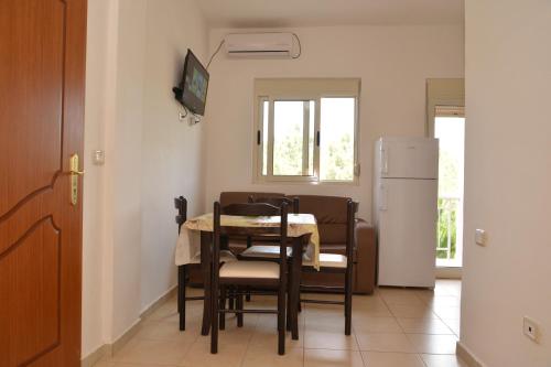 a kitchen with a table and chairs and a refrigerator at Hotel Gonaj in Velipojë