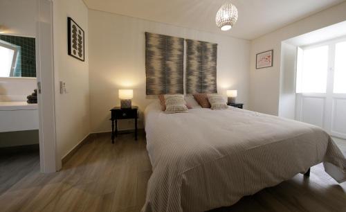 a bedroom with a bed with two lamps and a window at Casa Do Gilao in Tavira