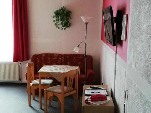 a living room with a table and a couch at Hotel Am Stadtwall in Anklam