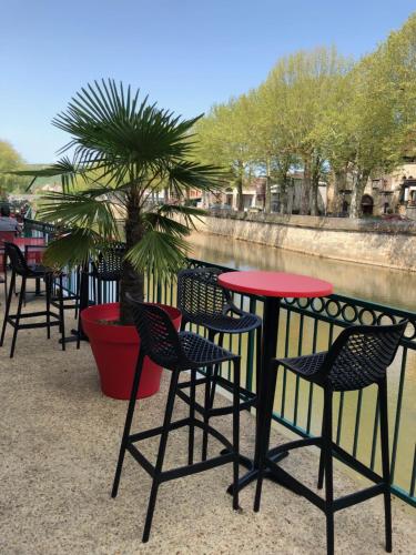 a row of tables and chairs in front of a river at Best Western Le Pont d'Or in Figeac