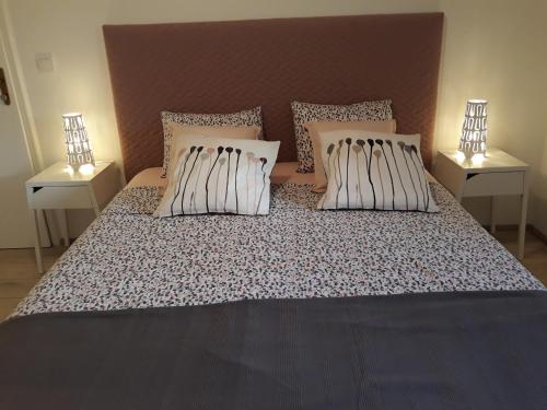 a bed with two pillows and two night stands at Petra Rooms and Apartments in Rab