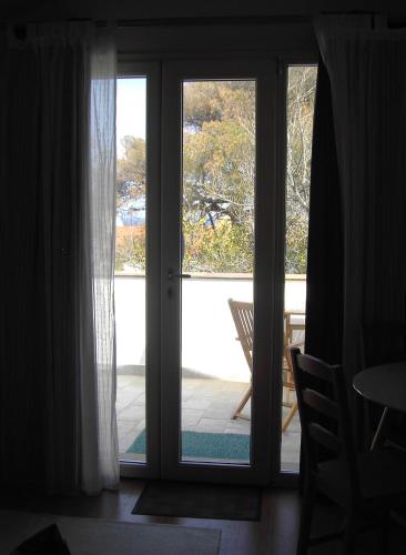 an open door to a patio with a chair outside at Il Gamberino in Capraia