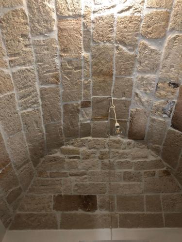 a room with a stone wall and a ceiling at Casa Profumi di Puglia in Castellana Grotte
