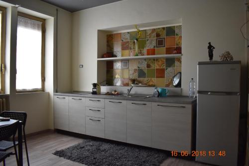 a kitchen with white cabinets and a refrigerator at Appartamento in centro in Cassino