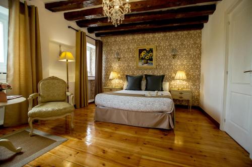a bedroom with a bed and a chair and a chandelier at Oriente Palace Apartments in Madrid