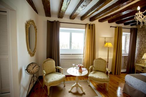 a room with two chairs and a table and a window at Oriente Palace Apartments in Madrid