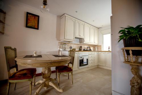 a kitchen with white cabinets and a table and chairs at Oriente Palace Apartments in Madrid