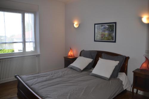 a bedroom with a bed with two pillows and a window at Gîte "Chez Paul" in Épinal