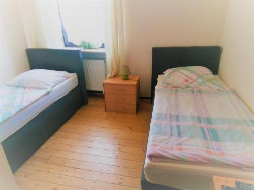 HeddesheimにあるHotel Kalimeraのウッドフロアの小さな部屋のベッド2台