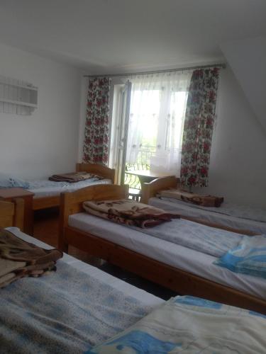 a room with three beds and a window at U Bafii in Gliczarów