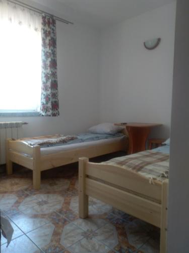 two beds in a room with a window at U Bafii in Gliczarów