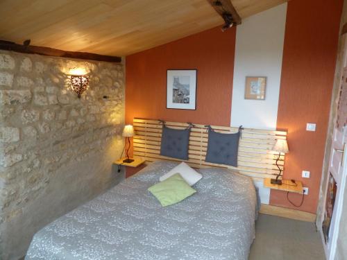 um quarto com uma cama e uma parede de pedra em La Maison Rouge em Chauvigny