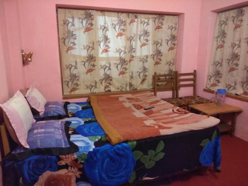 a bedroom with two twin beds and a window at Hotel Jannat in Srinagar