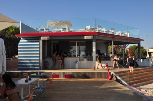 a building on the beach with people walking around at Hotel Intervallo in Torre Lapillo
