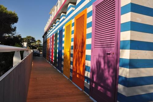 a colorful wall with colorful doors on a building at Hotel Intervallo in Torre Lapillo