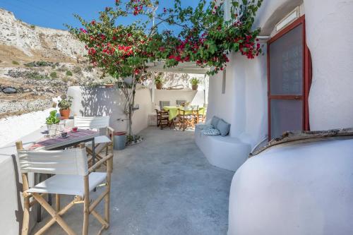 a patio with a table and chairs and flowers at Traditional Farmers Caves in Emporio
