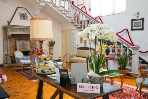a living room with a table with flowers on it at Hotel La Vela-Castello Il Rifugio in Santa Margherita Ligure